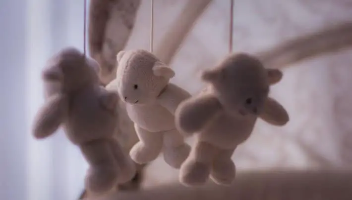 teddy bears hanging over crib