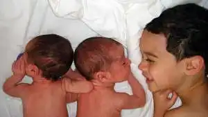 Identical twin babies with older brother