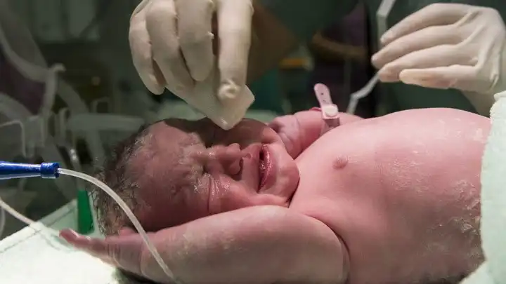 Newborn baby being wiped off