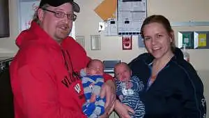 family with newborn identical twins at hospital