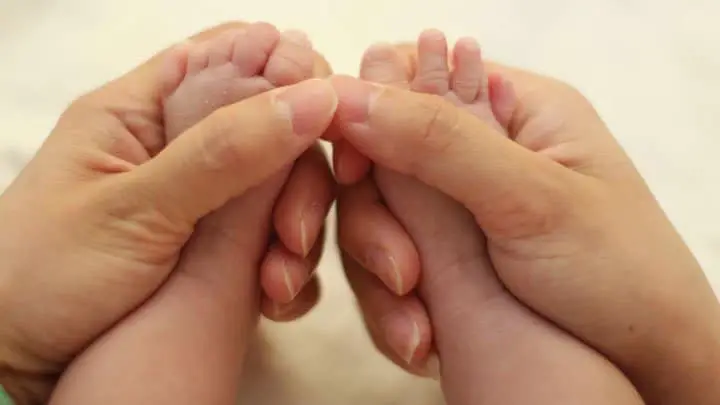 mom holding babies feet in hands