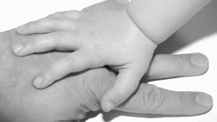 Baby hand on top of fathers hand