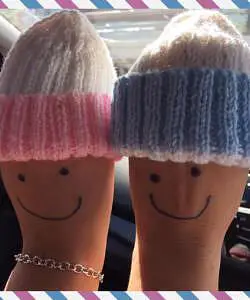 Two fingers dressed with hats and faces symbolizing fraternal twins